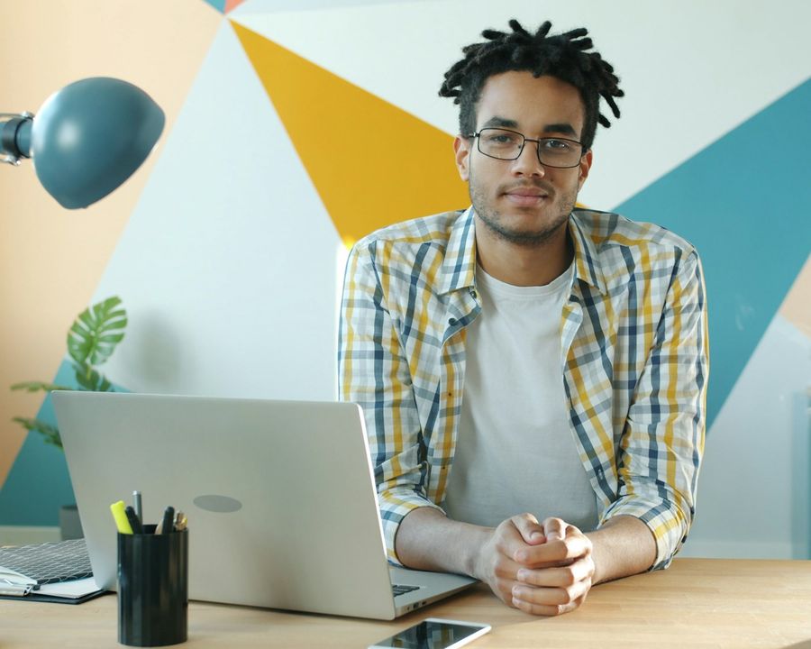 A business owner at a desk with a laptop and a steaming mug of coffee