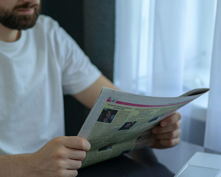 A man reading the morning paper over a cup of coffee at his table
